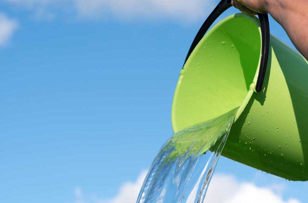 a green bucket of water being poured