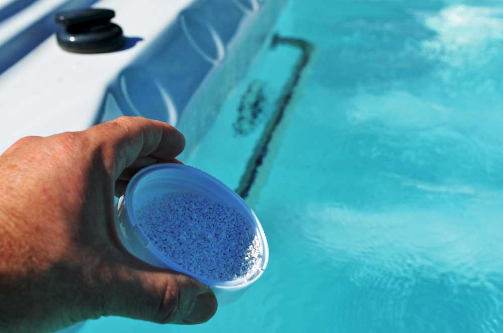 hot tub chemicals being poured into a hot tub