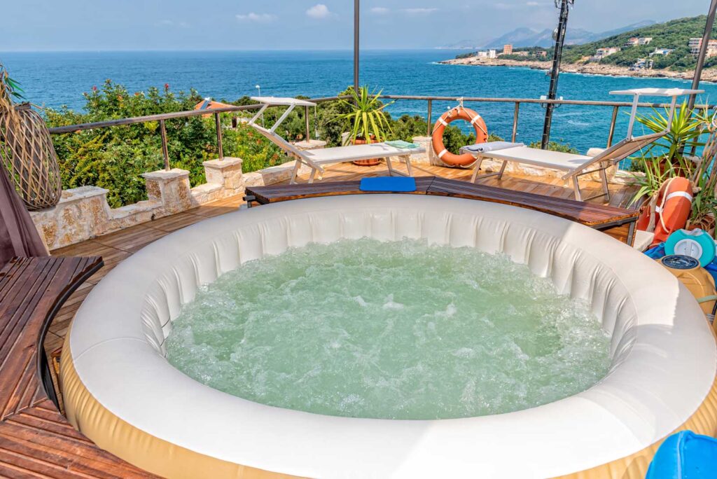 inflatable hot tub sunk in decking overlooking the sea