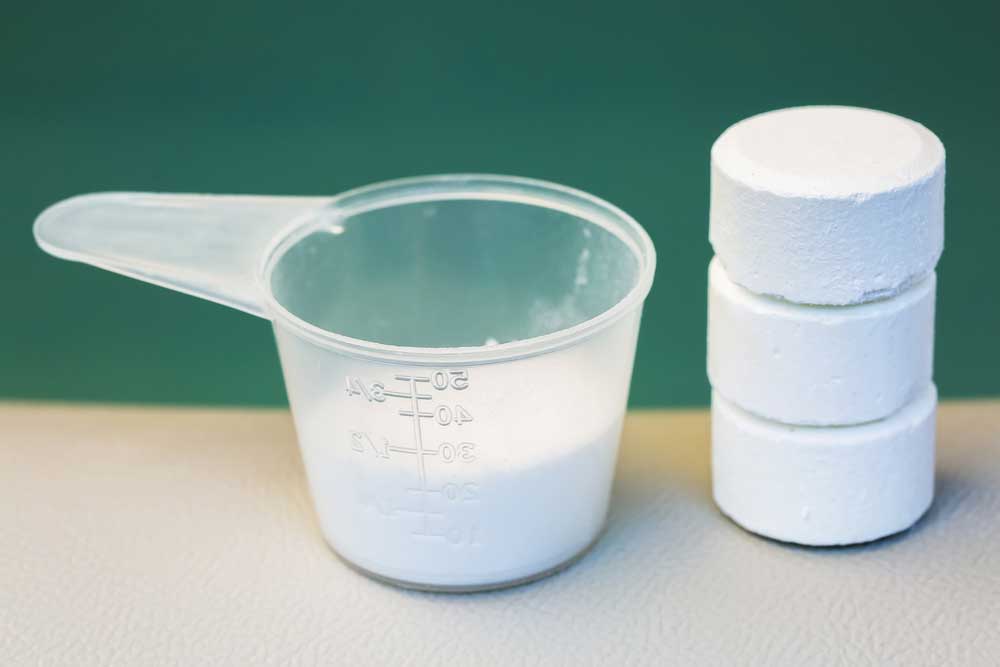 white powder in a scoop and three tablets stacked on top of eachother