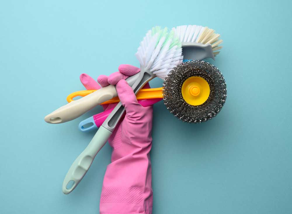 a hand with three cleaning brushes in it
